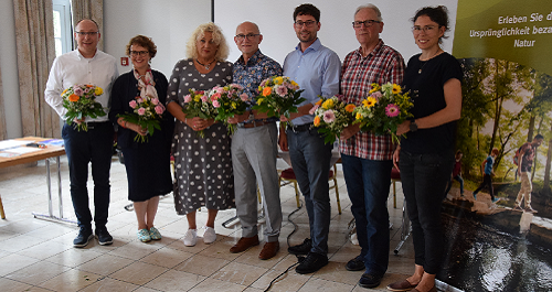 Vorstandsmitglieder stehendmit Blumensträußen